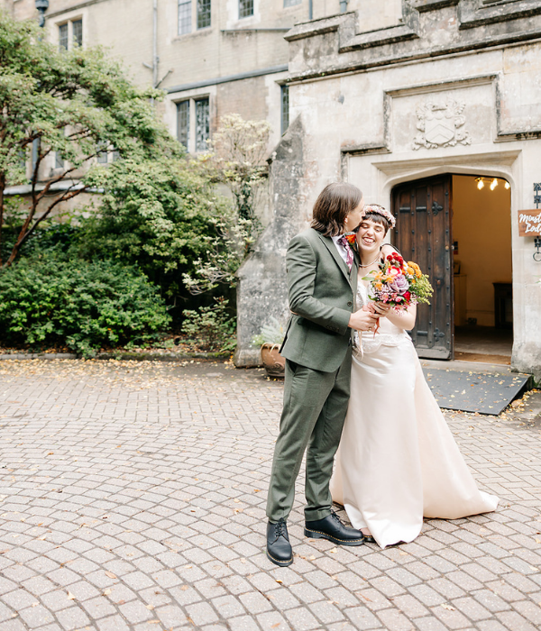 Bride and Groom standing outside a large wooden door